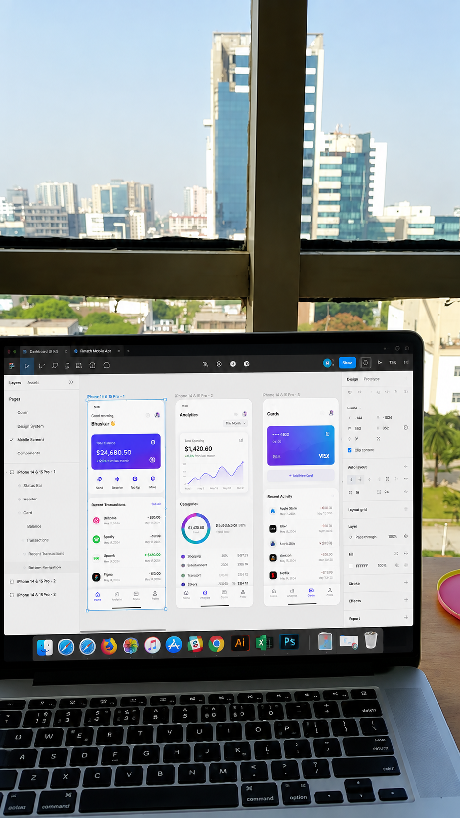Figma mobile app design open on a laptop with a city skyline in the background